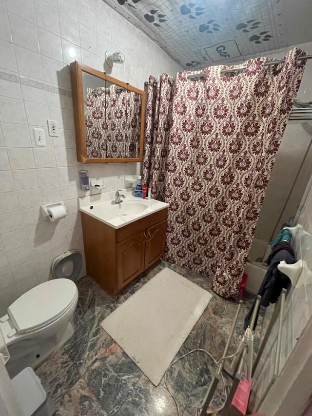 full bathroom featuring vanity, shower / bath combo, toilet, and tile walls