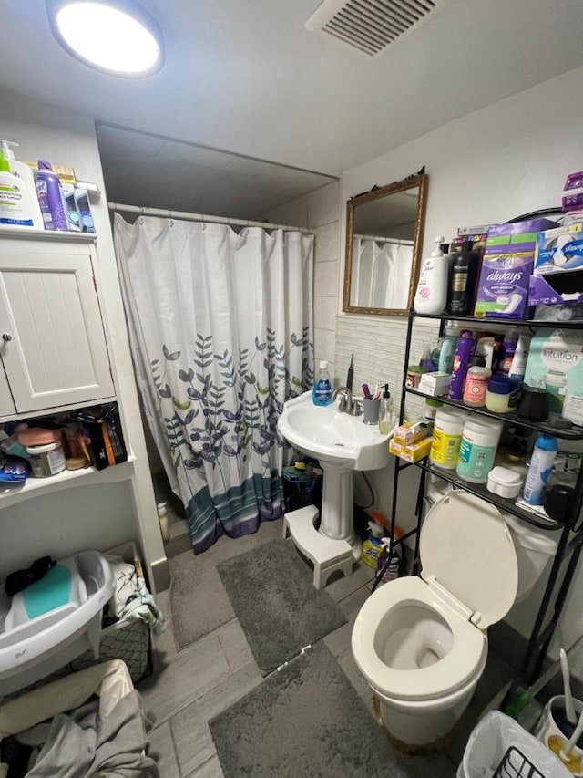 bathroom featuring a shower with curtain and toilet