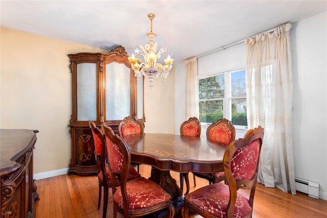 dining area with an inviting chandelier, a baseboard radiator, and light wood-type flooring