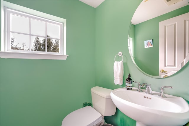 bathroom featuring sink, toilet, and a healthy amount of sunlight