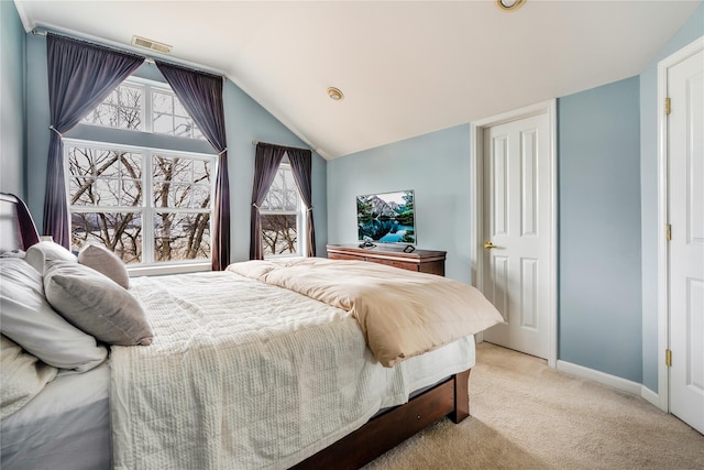 carpeted bedroom with lofted ceiling and multiple windows