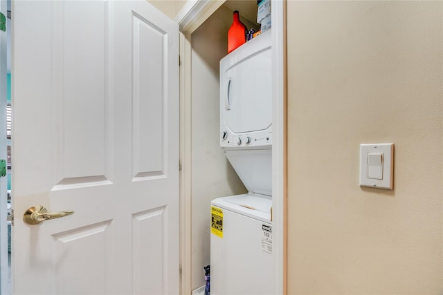 clothes washing area featuring stacked washing maching and dryer