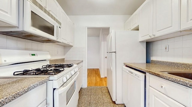 kitchen with white appliances, decorative backsplash, and white cabinetry