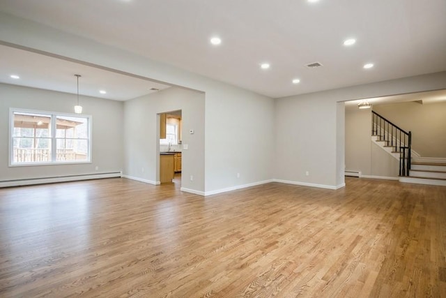 unfurnished living room with a baseboard radiator, light hardwood / wood-style flooring, and sink