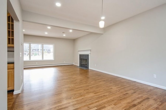 unfurnished living room with beam ceiling, baseboard heating, and light hardwood / wood-style flooring