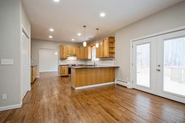 kitchen featuring french doors, a baseboard radiator, kitchen peninsula, decorative light fixtures, and stainless steel stove