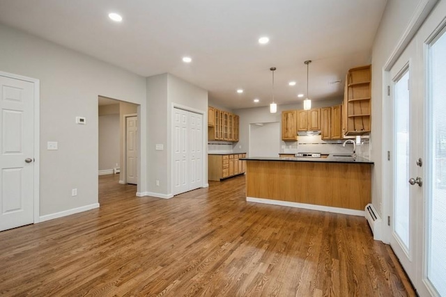 kitchen with decorative light fixtures, dark hardwood / wood-style floors, decorative backsplash, and kitchen peninsula