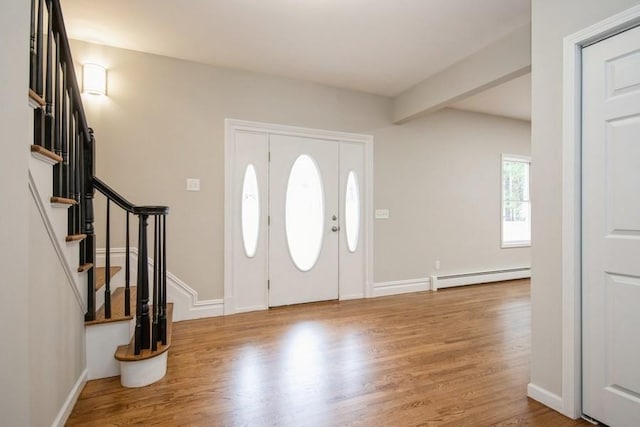 foyer entrance featuring light wood-type flooring and a baseboard heating unit