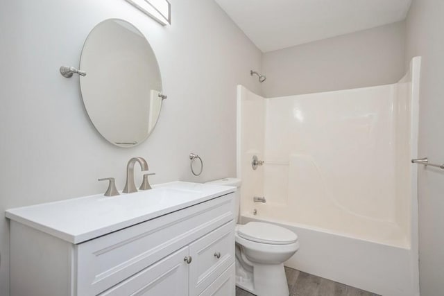 full bathroom with toilet, hardwood / wood-style floors, vanity, and tub / shower combination