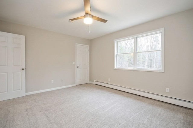 carpeted spare room featuring baseboard heating and ceiling fan