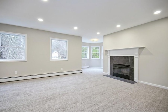 unfurnished living room featuring light carpet, a tile fireplace, and a baseboard radiator