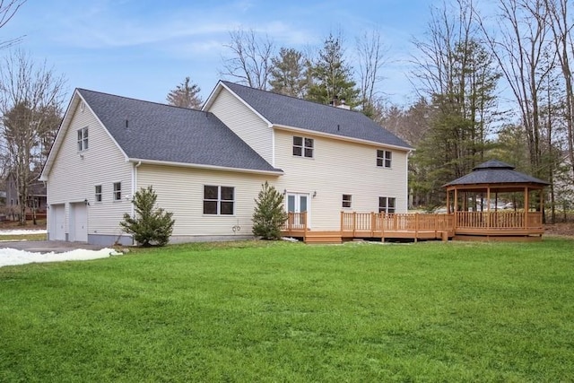 back of property with a gazebo, a wooden deck, a lawn, and a garage