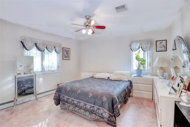 bedroom with light carpet, ceiling fan, and a baseboard heating unit