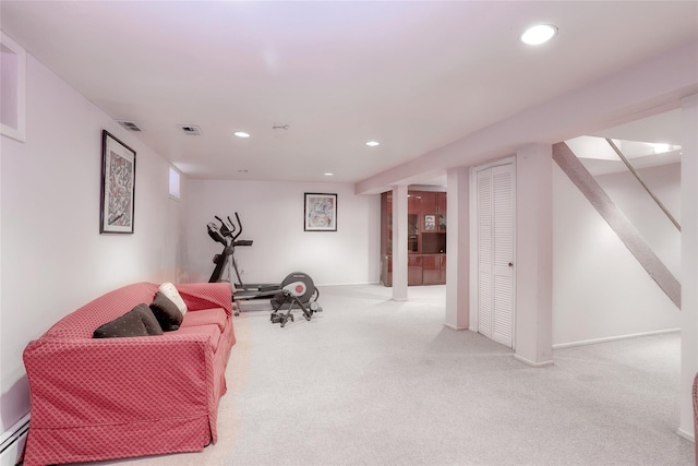 exercise room featuring light carpet and a baseboard radiator