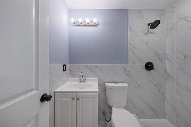 bathroom with vanity, toilet, and tiled shower