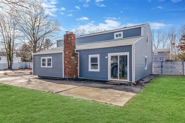 rear view of house with a lawn and a patio