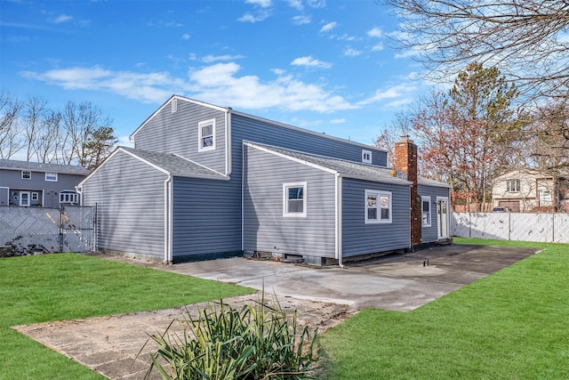 rear view of property featuring a patio area and a lawn