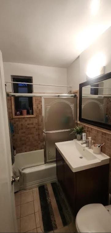 full bathroom featuring backsplash, tile patterned floors, vanity, enclosed tub / shower combo, and toilet