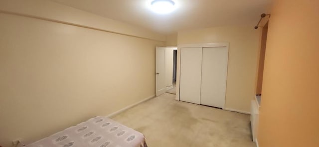 unfurnished bedroom featuring light carpet and a closet