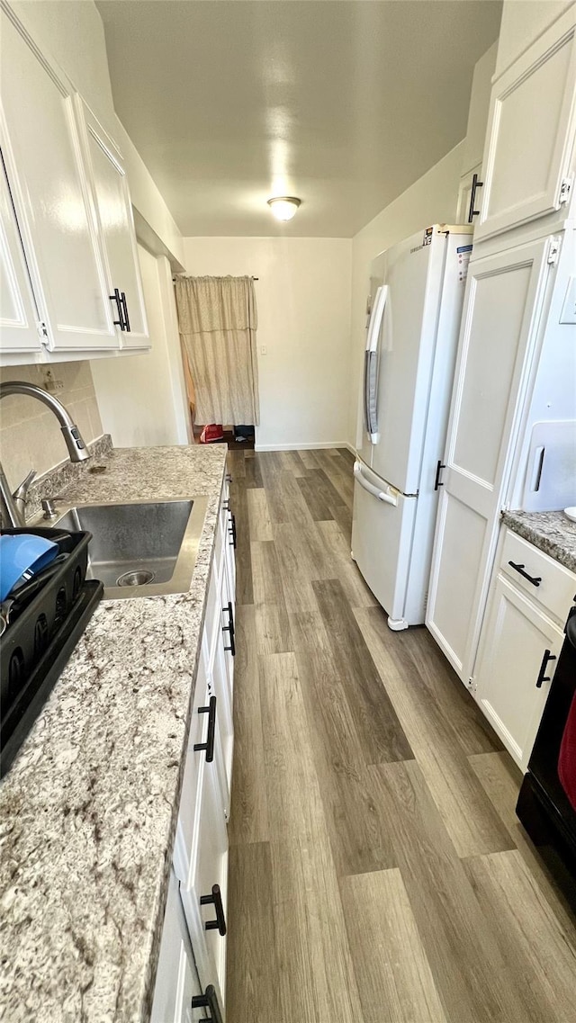 kitchen featuring sink, white cabinets, and white refrigerator