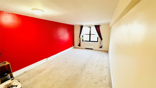 carpeted spare room featuring radiator