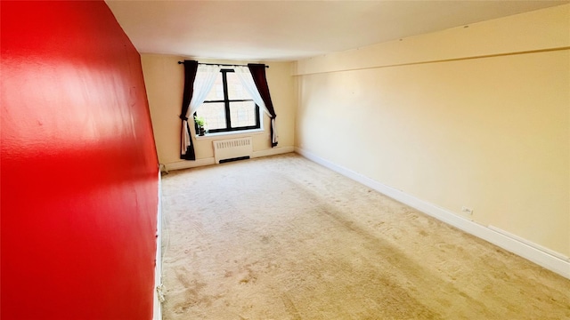 carpeted spare room featuring radiator heating unit