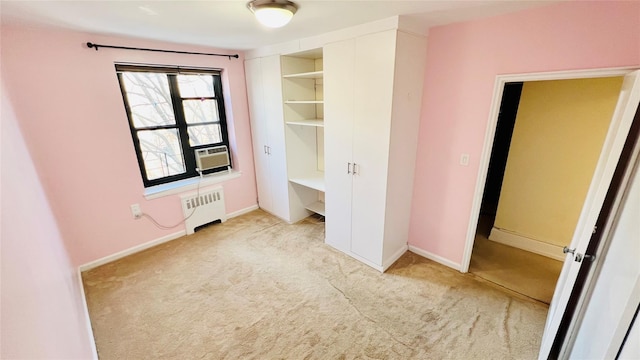 unfurnished bedroom with cooling unit, radiator heating unit, and light colored carpet