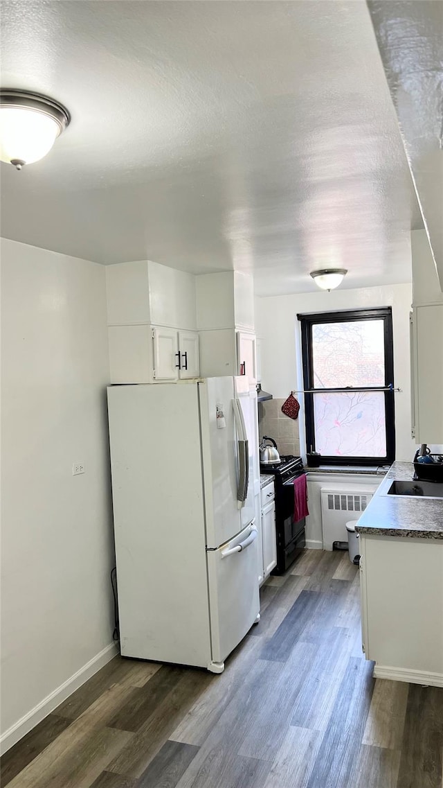 kitchen with white cabinetry, white fridge, sink, and black range with gas cooktop