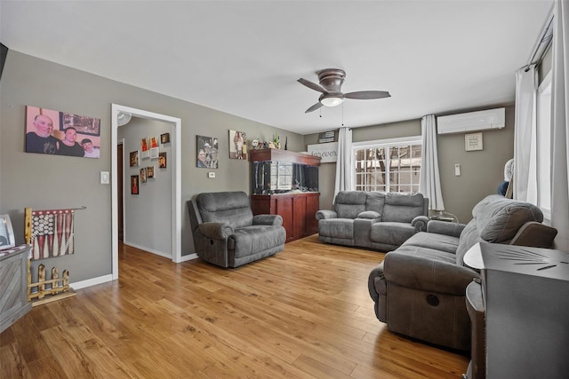 living room featuring wood-type flooring, an AC wall unit, and ceiling fan