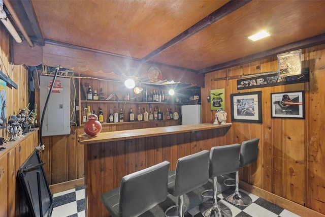 bar featuring beam ceiling, electric panel, and wood walls