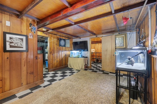 misc room featuring beam ceiling and wood walls