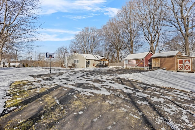 snowy yard with a storage shed