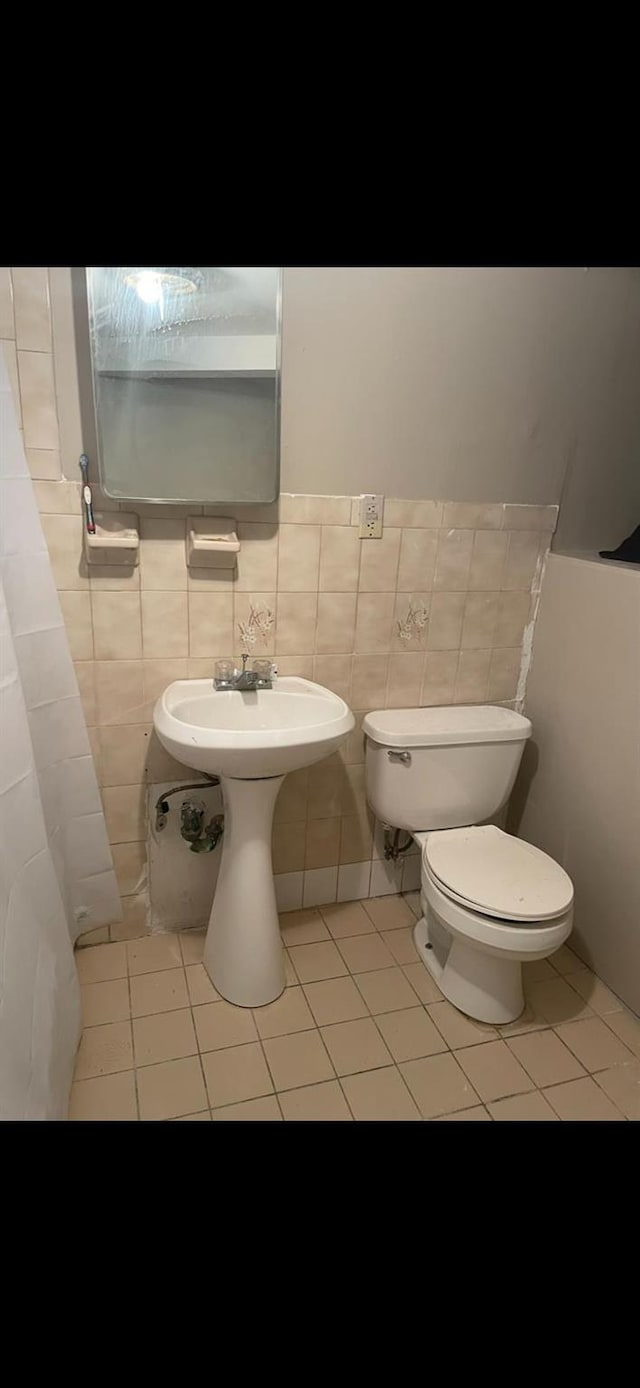 bathroom with tile walls, tile patterned flooring, and toilet