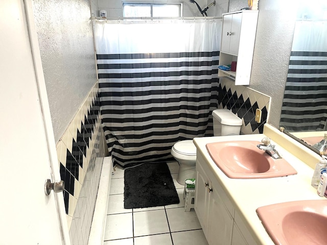 bathroom featuring toilet, vanity, tile walls, tile patterned floors, and a shower with shower curtain