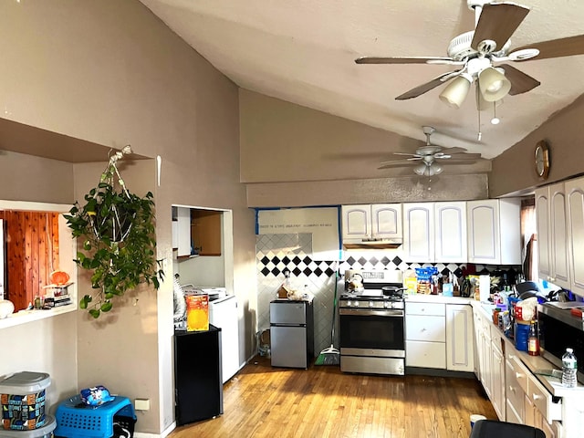 kitchen with vaulted ceiling, white cabinetry, stainless steel appliances, decorative backsplash, and light wood-type flooring