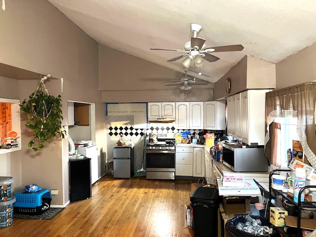 kitchen featuring lofted ceiling, white cabinetry, stainless steel appliances, ceiling fan, and light hardwood / wood-style flooring