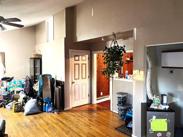 interior space with hardwood / wood-style flooring, a baseboard heating unit, and ceiling fan