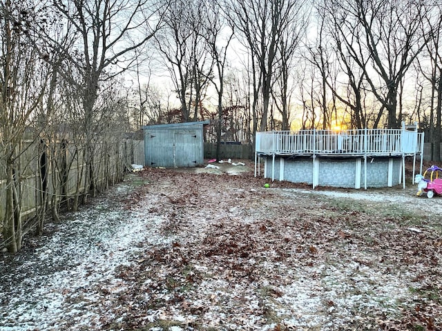 yard at dusk with a shed and a swimming pool side deck