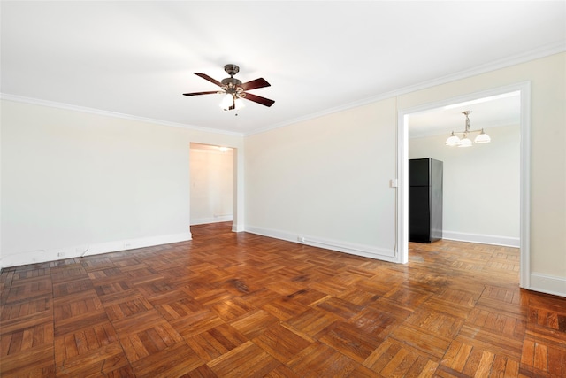 spare room featuring dark parquet flooring, ornamental molding, and ceiling fan with notable chandelier