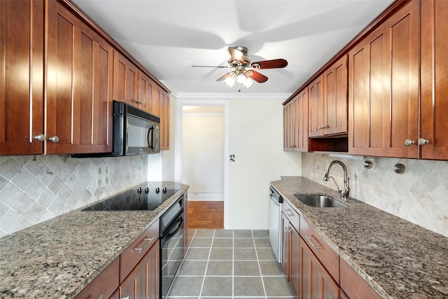 kitchen featuring black appliances, decorative backsplash, light stone countertops, and sink