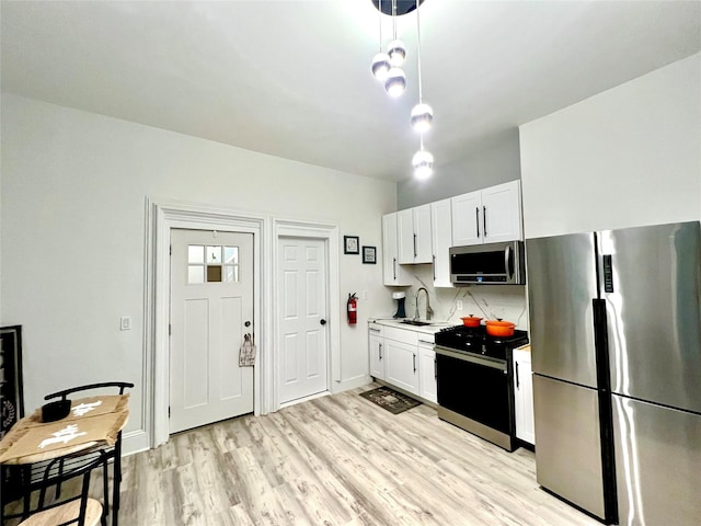 kitchen featuring appliances with stainless steel finishes, sink, white cabinets, and decorative backsplash