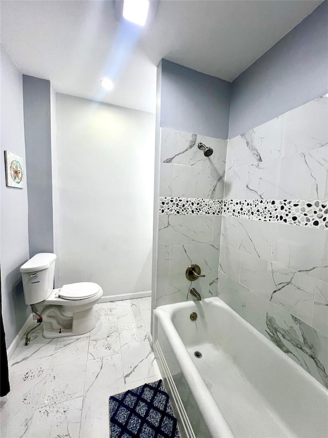 bathroom featuring tiled shower / bath combo and toilet