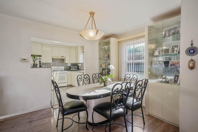 dining space featuring dark hardwood / wood-style floors and crown molding