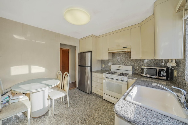 kitchen featuring cream cabinetry, sink, appliances with stainless steel finishes, and tasteful backsplash