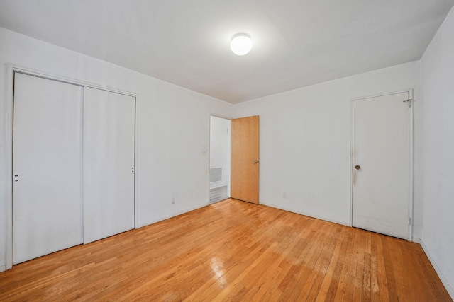 unfurnished bedroom with a closet and light hardwood / wood-style flooring