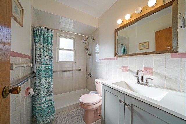 bathroom with curtained shower, tile patterned flooring, toilet, vanity, and tile walls