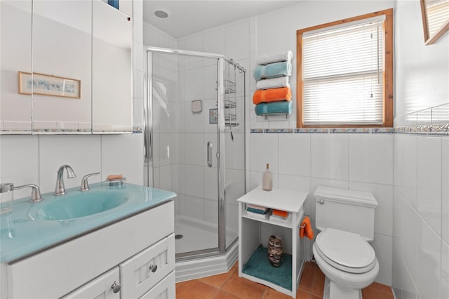 bathroom with toilet, vanity, tile patterned flooring, tile walls, and an enclosed shower