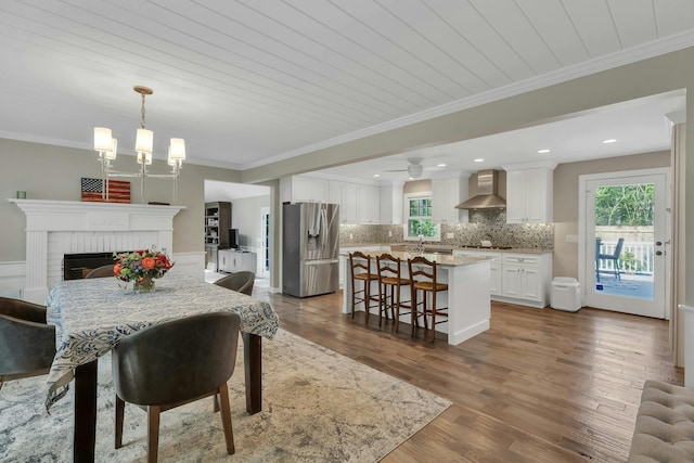 dining area with hardwood / wood-style flooring, ornamental molding, wood ceiling, and a brick fireplace