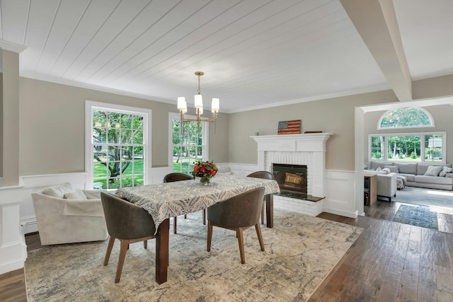 dining area featuring baseboard heating, dark hardwood / wood-style flooring, a fireplace, and plenty of natural light