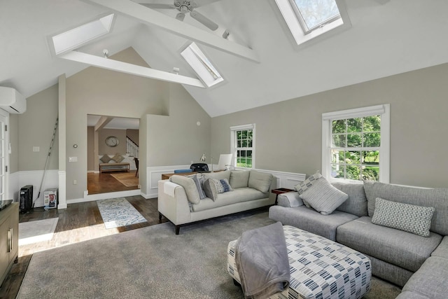 living room with a wall mounted AC, ceiling fan, plenty of natural light, and a skylight